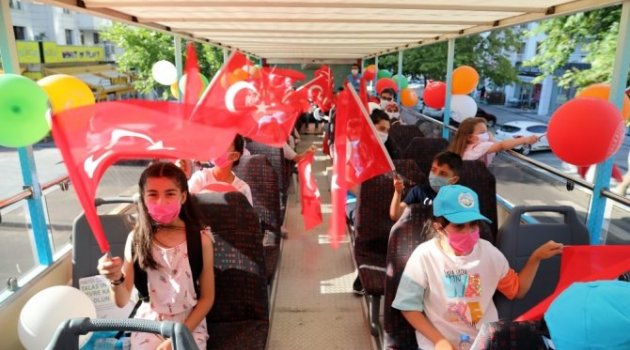 Kitap okuyan çocuklar üstü açık otobüsle gezdi